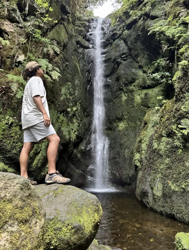 Poço das Pulgas hiker beside a narrow waterfall